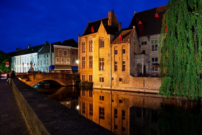 Bruges canal at night with illuminated buildings and bridge