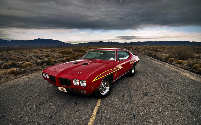 Red Pontiac GTO on a desert road