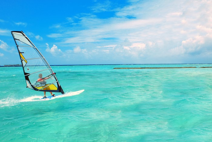 Windsurfing on a turquoise sea under a cloudy sky
