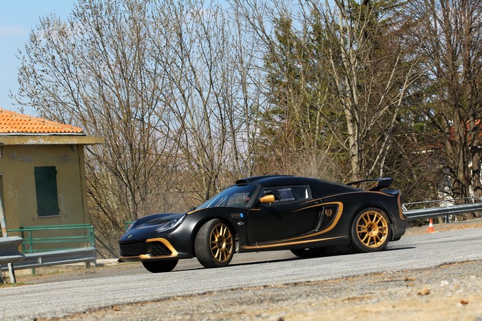 Black Lotus Exige R-GT rally car with gold accents