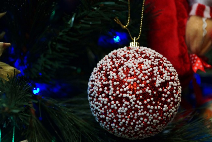 Christmas ornament on a tree with blue lights