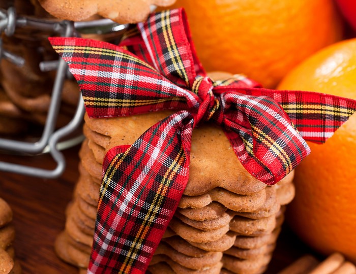 Gingerbread cookies tied with a plaid bow and oranges