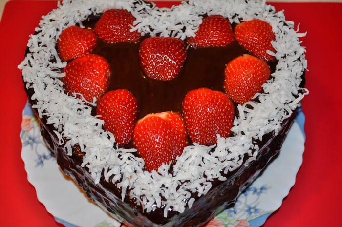 Heart-shaped chocolate cake with strawberries and coconut