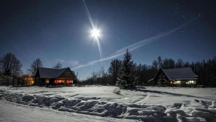 Winter night in a Russian village with snow and moon