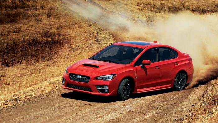 Red 2015 Subaru WRX driving on a dirt road