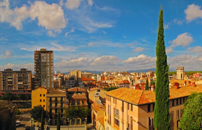 Cityscape of Girona, Spain with buildings and cypress tree