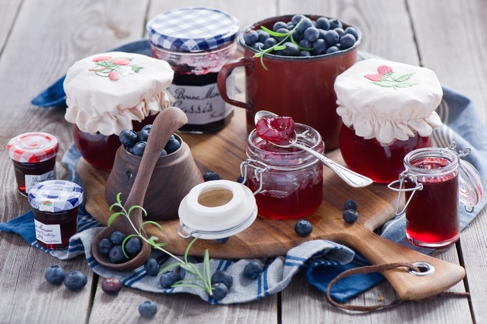 Still life of blueberry jam jars and fresh blueberries
