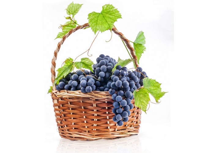 Grapes in a wicker basket with leaves