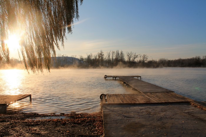 Wooden docks on a misty lake at sunrise