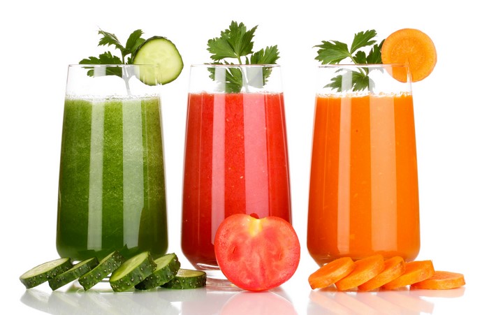 Three glasses of fresh juice with garnishes