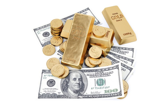 Gold bars and coins with US dollar banknotes