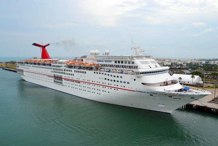 Carnival Ecstasy cruise ship docked at a marina