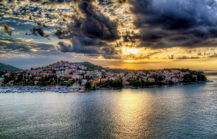 Coastal town with houses and boats at sunset