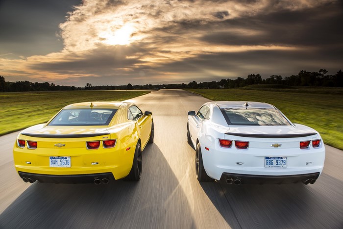 Yellow and White Chevrolet Camaros on a Road