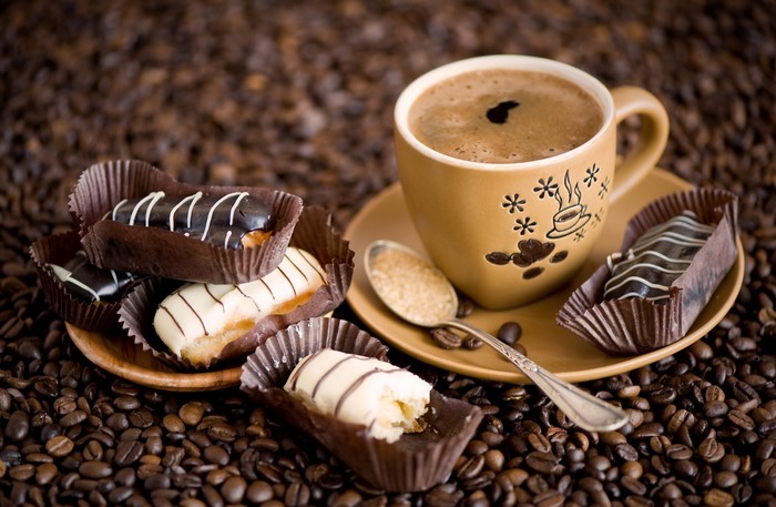 Coffee cup with eclairs and coffee beans