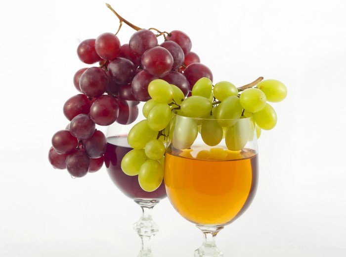 Red and green grapes with wine in glasses