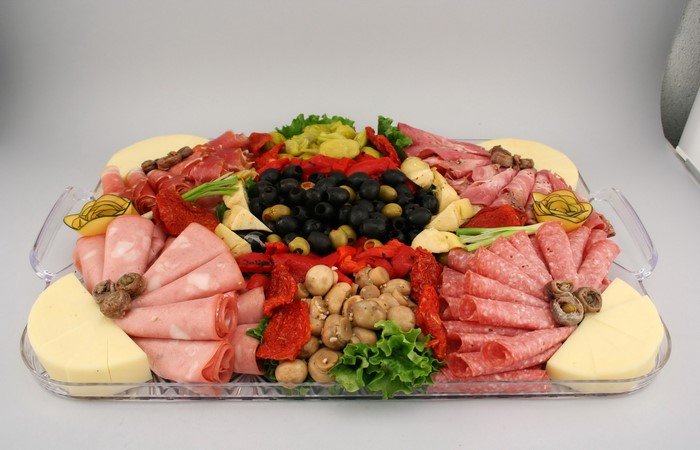 Charcuterie board with meats, cheeses, olives, and mushrooms