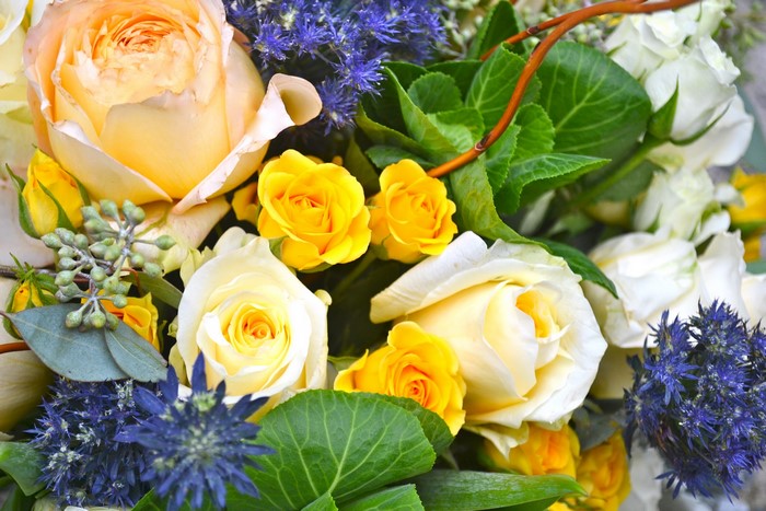 Yellow and white roses with blue thistle bouquet