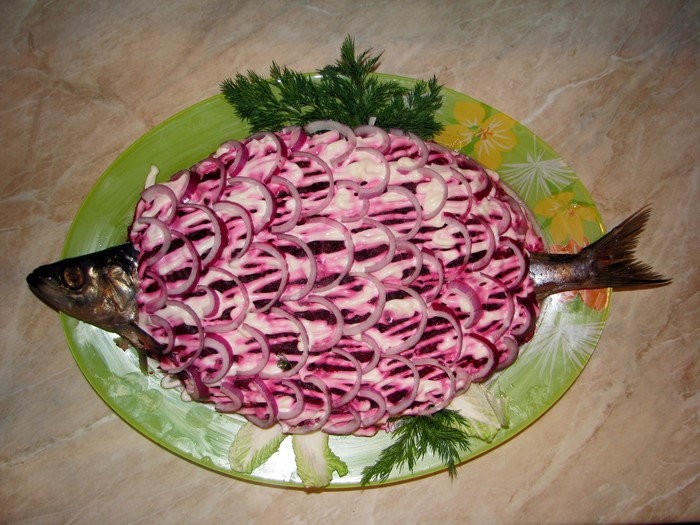 Fish salad decorated with beet and onion slices