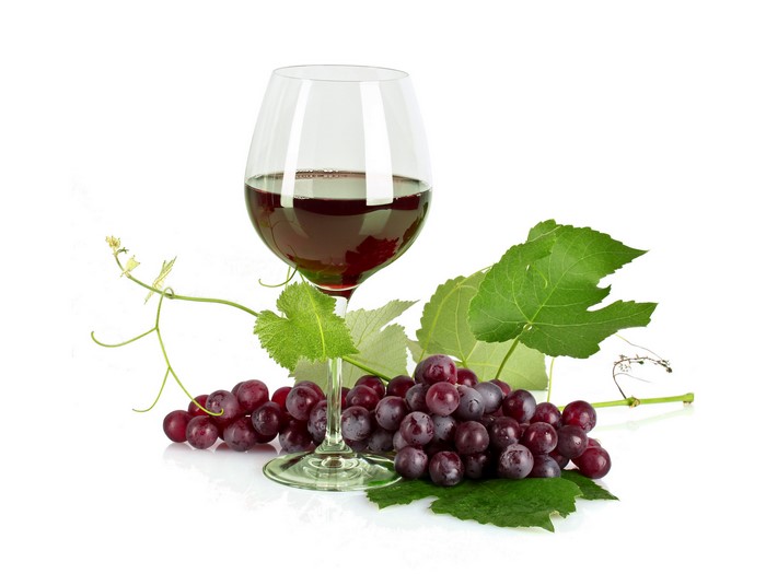 Red wine in a glass with grapes and leaves