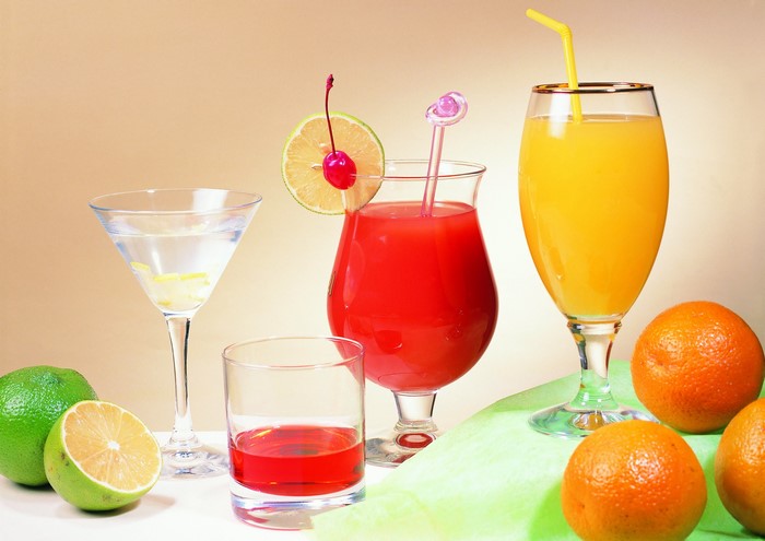 Assorted colorful cocktails and fruits on a table