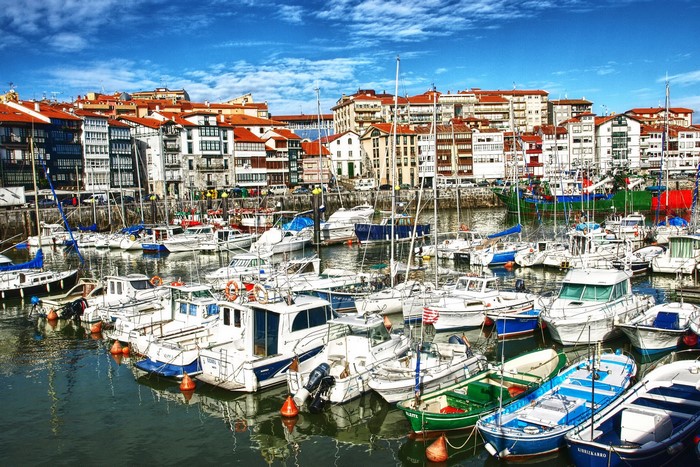 Boats docked in a harbor with buildings in Markina-Ondarro, Spain