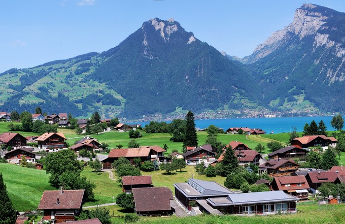 Houses in a Swiss village with mountains and a lake