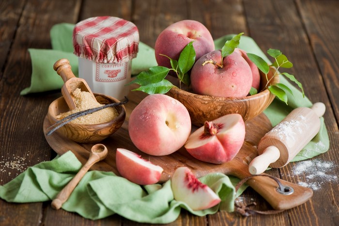 Peaches and baking ingredients on a wooden table