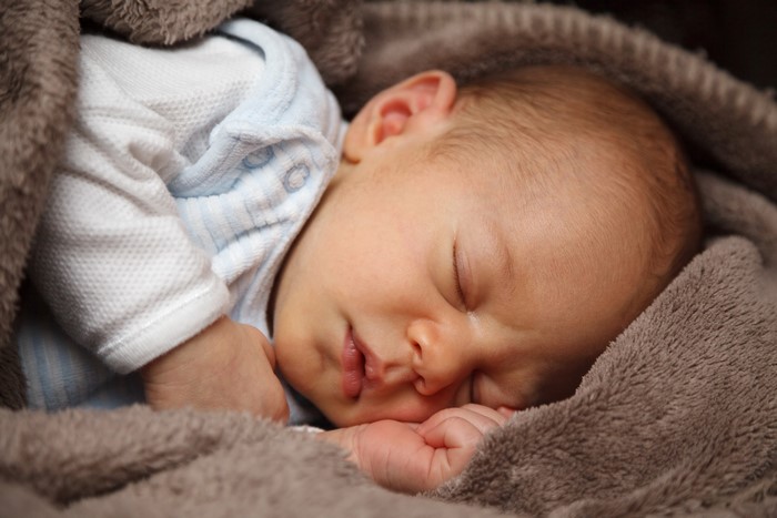 Infant sleeping wrapped in a blanket