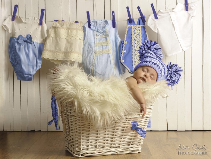 Baby in a basket with clothes on a line