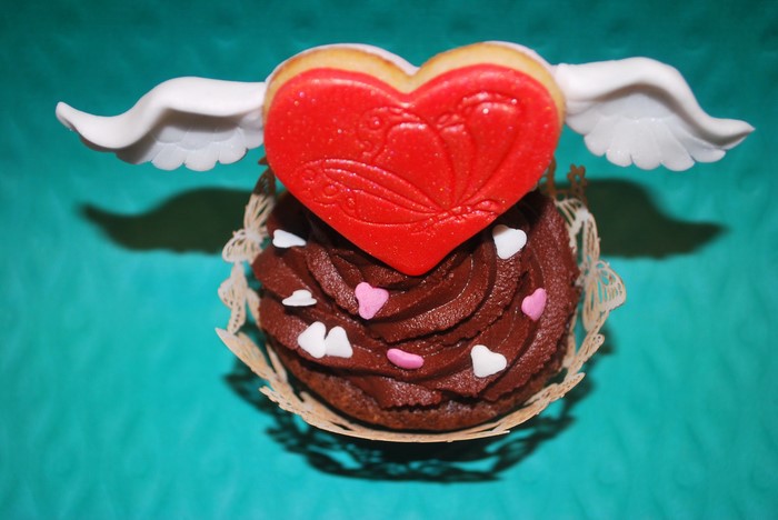 Chocolate cupcake with heart cookie and wings