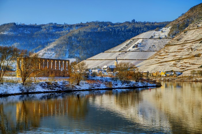 Ruins and village on a riverbank in winter, Brem, Germany