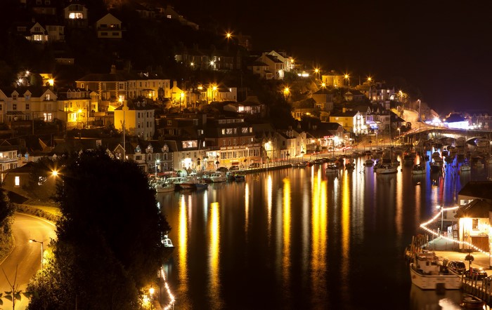 Town lights reflecting on water at night in Looe, Cornwall