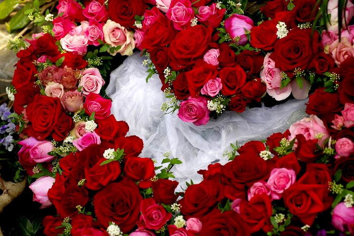 A heart-shaped arrangement of red and pink roses