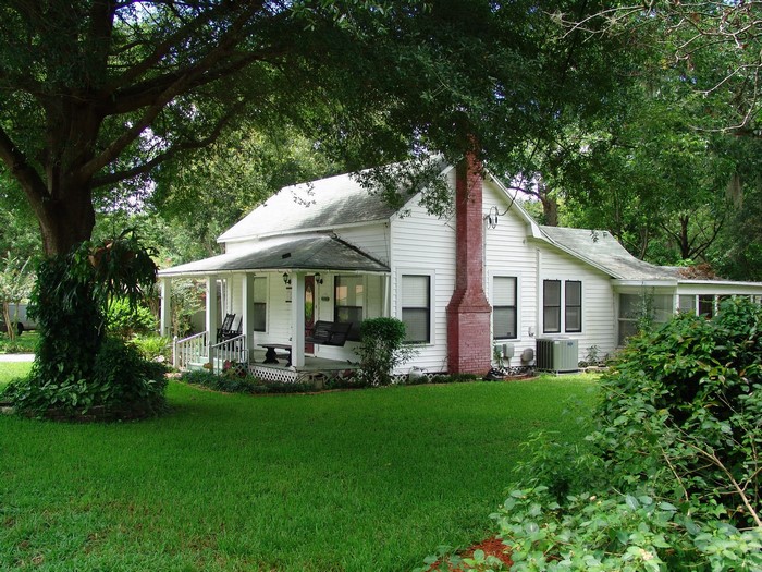 White house with porch and large tree in Plant City, Florida