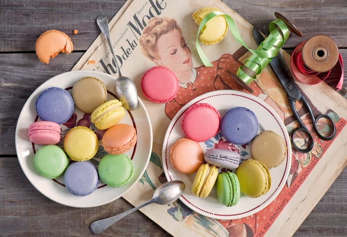 Macarons on plates with vintage magazine and scissors
