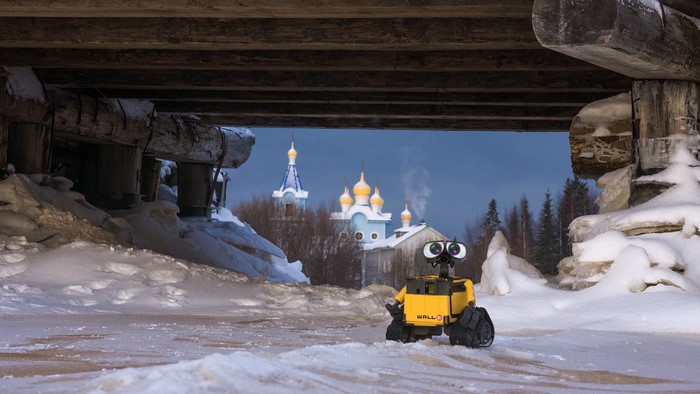 WALL-E toy in a snowy landscape with a church