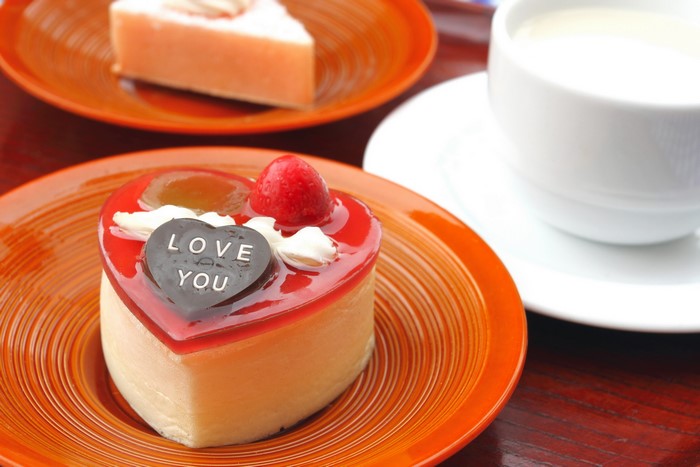 Heart-shaped cake with 'Love You' inscription and a cup of milk