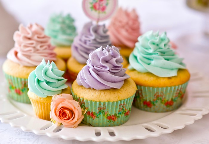 Pastel frosted cupcakes on a white platter