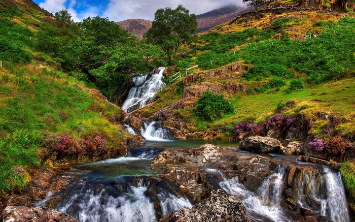 Waterfall cascading down a rocky, green hillside
