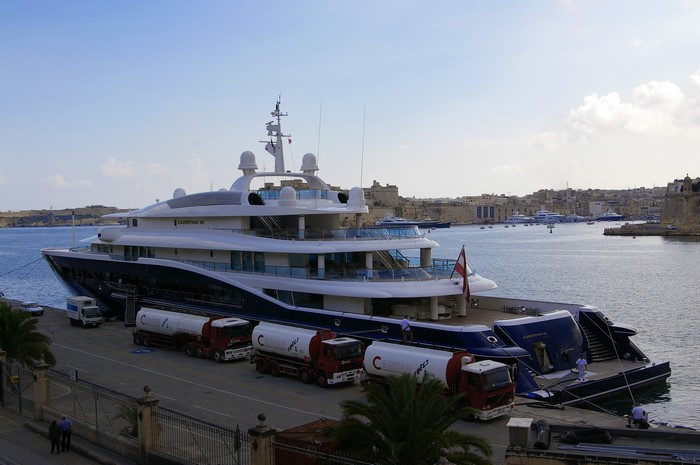 Carinthia VII Yacht docked at a marina with fuel trucks