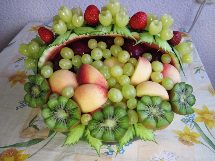 Fruit basket with grapes, peaches, kiwi, and strawberries