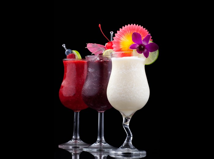 Three colorful cocktails with garnishes