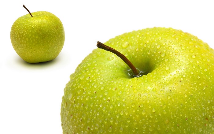 Two green apples with water drops