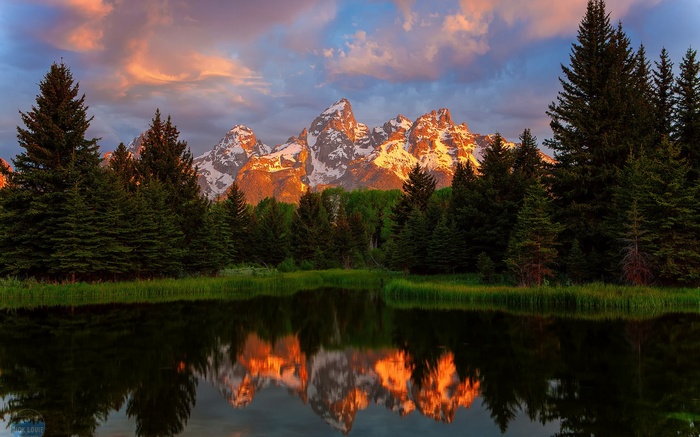 Grand Teton Mountains reflected in a lake at sunrise