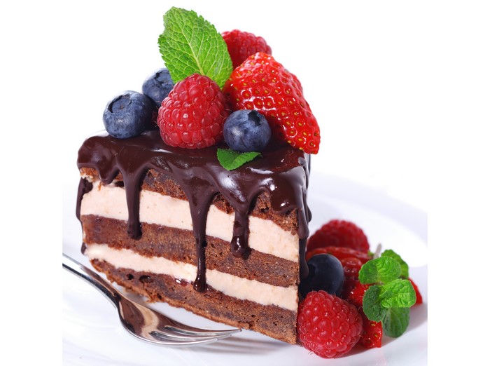 Chocolate cake slice with berries and mint