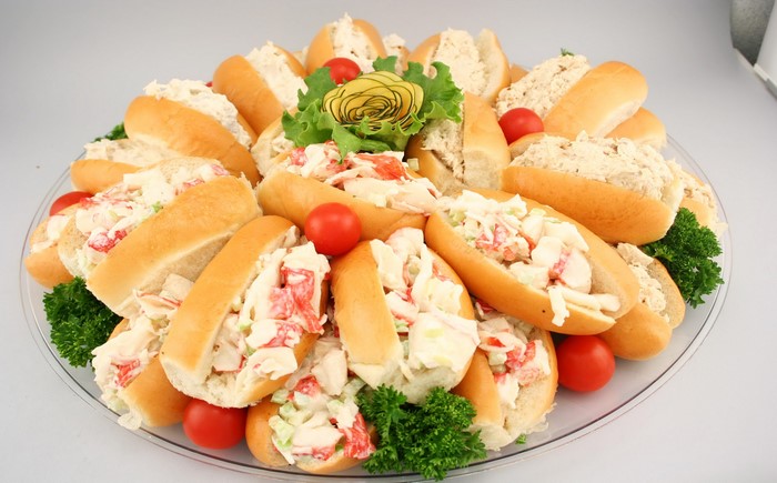 Seafood salad sandwiches on buns with cherry tomatoes and parsley
