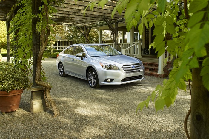 Silver 2015 Subaru Legacy sedan parked under a pergola