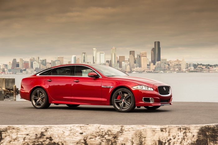 Red 2014 Jaguar XJR parked by a city skyline
