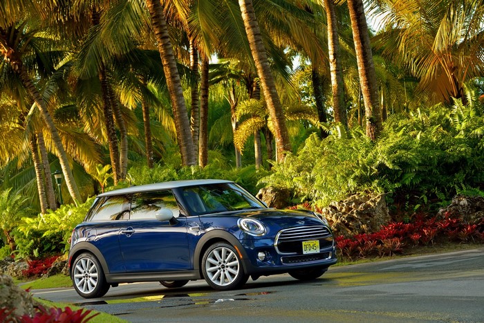 Blue Mini Cooper F56 parked by palm trees
